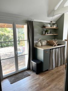 eine Küche mit einer Theke mit einem Tisch und einem Fenster in der Unterkunft Studio du Grand Beaumont in Saint-Mélaine-sur-Aubance
