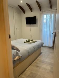 a bedroom with a bed and a flat screen tv at Casa rústica en Madrid recién reformada in Madrid