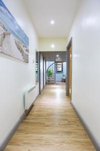 a hallway with white walls and a wooden floor at A105 Stylish City loft in Coventry