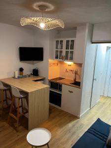 a small kitchen with a table and a counter top at Studio Chaleureux au Cap d’Agde in Cap d'Agde
