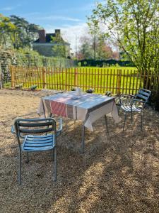 einem Tisch mit zwei Stühlen und einem Tisch mit in der Unterkunft Studio du Grand Beaumont in Saint-Mélaine-sur-Aubance