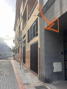 een gebouw met een oranje pijl aan de zijkant bij Valle Gran Rey- La Playa in La Playa Calera