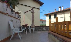 eine Terrasse mit einem Sonnenschirm, Stühlen und einem Tisch in der Unterkunft B&B Casa Fei in Signa