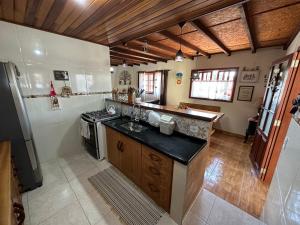 a kitchen with a sink and a stove at Recanto Luar in Camanducaia