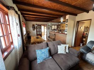 een woonkamer met een bruine bank en een keuken bij Recanto Luar in Camanducaia