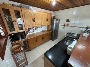 a kitchen with wooden cabinets and a refrigerator at Recanto Luar in Camanducaia