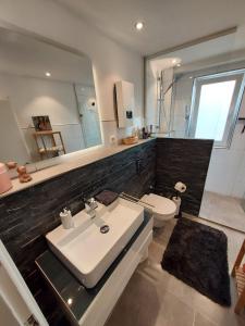 uma casa de banho com um lavatório branco e um WC. em Seibels SUITES - Wohnung Ruhrgebiet em Herne