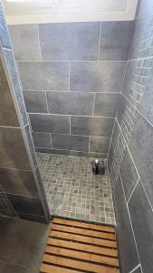 y baño con ducha de azulejos y suelo de madera. en Exceptionnel, 5' du village de cassis, vue féerique, piscine, parking, en Cassis