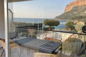 balcón con banco y vistas al océano en Exceptionnel, 5' du village de cassis, vue féerique, piscine, parking, en Cassis