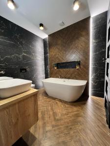 a bathroom with two sinks and a bath tub at 8 Apartment BREZY VYSOKÉ TATRY in Stará Lesná