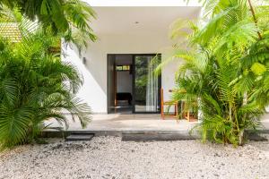 a house with a courtyard with palm trees at Little Hawaii Avellanas in Playa Avellana