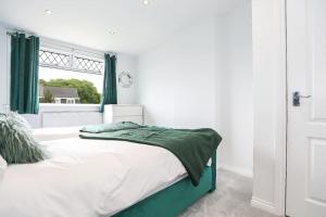 a bedroom with a bed with green curtains and a window at Doralan in Bishopbriggs