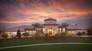 una gran casa blanca con una puesta de sol en el fondo en Champions Gate Resort - 5b4b Villa, en Davenport