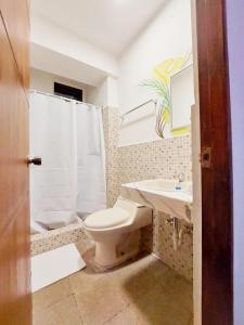 a bathroom with a toilet and a sink and a shower at Hotel Caracas in Panama City