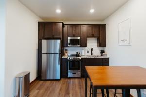 uma cozinha com armários de madeira e um frigorífico de aço inoxidável em Big Mountain Studio at Switchback Suites em Kalispell
