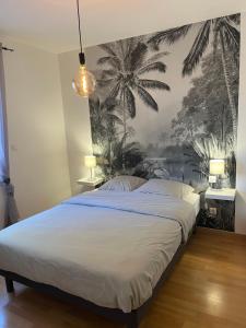 a bedroom with a large bed with palm trees on the wall at Maison à biscarrosse avec piscine et jacuzzi in Biscarrosse +9 photos