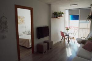 a living room with a bed and a table and a mirror at Edificio La Isla in Puerto de Mazarrón