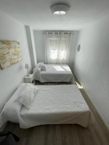 a bedroom with two beds and a window at Edificio La Isla in Puerto de Mazarrón