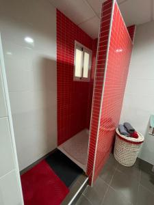 y baño con ducha de azulejos rojos y suelo de baldosa roja. en Edificio La Isla en Puerto de Mazarrón