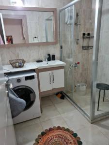 a bathroom with a washing machine and a shower at Cozy two-room apartment for living in Erdemli