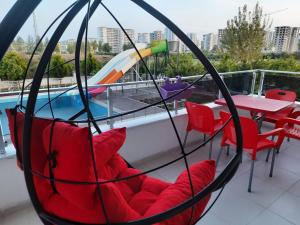 un columpio con sillas, una mesa y una piscina en Cozy two-room apartment for living, en Erdemli
