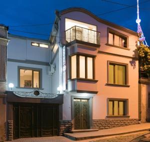 a large pink building with a balcony and a door at Boutique Stay in Tbilisi City