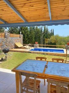 un patio con mesa, sillas y piscina en Villa Rengin Datça (Havuzlu) Günlük Haftalık Kiralık en Datca