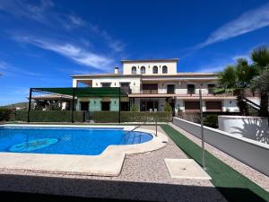 uma casa grande com uma piscina em frente em Casa Rural El Mirador de la Atalaya em Villanueva de Algaidas