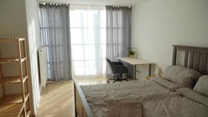 1 dormitorio con cama, escritorio y ventana en Das Neukirchen Inn en Neuburg am Inn