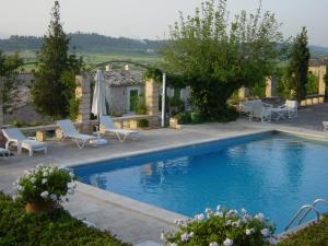 einen Pool mit Stühlen und ein Haus in der Unterkunft Agroturismo sa Rota d' en Palerm in Lloret de Vistalegre