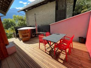 una terraza de madera con mesa y sillas. en Le Cristal Montvernier, en Montvernier