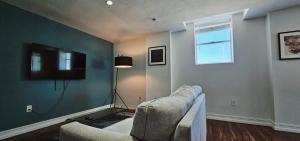 a living room with a couch and a television at The Lofts on Clematis 301 Downtown West Palm Beach in West Palm Beach