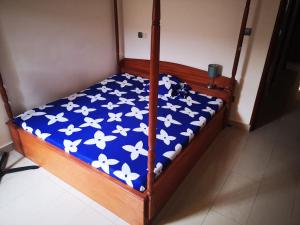 uma cama com um edredão azul com borboletas brancas em Villa toute équipée à Arconville em Abomey-Calavi