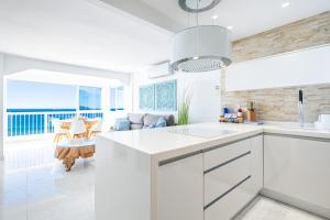 een witte keuken met uitzicht op de oceaan bij Veracruz 5-C Deluxe Apartment Levante Beach in Benidorm