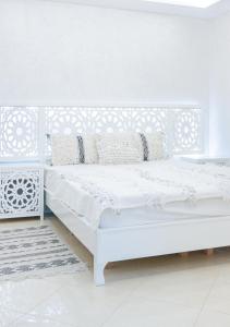 um quarto branco com uma cama branca num quarto em Malak House em Imsouane