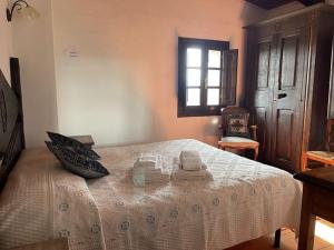 a bedroom with a bed with two towels and a window at Agriturismo Il Muto di Gallura in Aggius