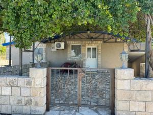 ein Haus mit einem Tor davor in der Unterkunft Apartments Airport Golubovci in Podgorica