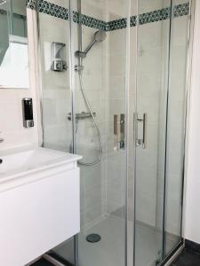 um chuveiro com uma porta de vidro na casa de banho em Le studio d'Angèle : KIMI em Bruz