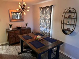 a dining room with a wooden table and a mirror at Charming 2 Bed Mid-City Living only 7 Min to Downtown in Tucson
