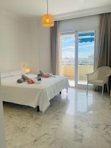 マルベーリャにあるSOLGUEST APARTAMENTO PUERTO BANUS, MARBELLA vistas espectaculares!!のベッドと大きな窓のある寝室 +20枚の写真