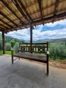 a bench sitting under a roof with a view at Espaço Lua Branca in Baependi