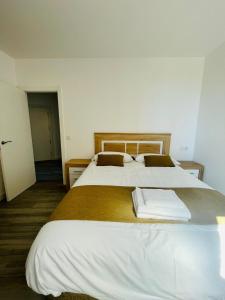 a bedroom with two beds with white sheets at Apartamentos Rurales La Plaza 1 in Duruelo de la Sierra