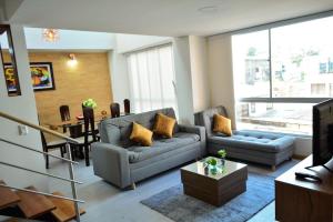 Sala de estar con 2 sofás y mesa en Apartamentos cómodos en Milan zona G, en Manizales