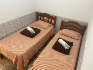 twee bedden in een kamer met bijpassende dekens en kussens bij SUA CASA EM BONITO-PE in Bonito