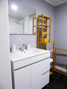 y baño con lavabo blanco y espejo. en Casas do Gavião by Portus Alacer, en Gavião