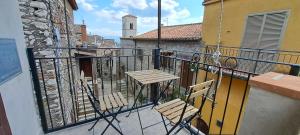 un balcón con 2 sillas de madera y un edificio en Casa la Gardenia, en SantʼOreste