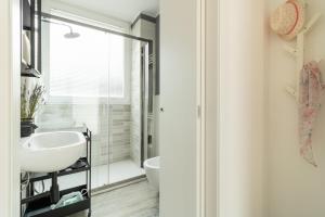 een badkamer met een witte wastafel en een douche bij Navigli - Chic and Sophisticated Home in Milan in Milaan