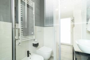 een witte badkamer met een wastafel en een toilet bij Navigli - Chic and Sophisticated Home in Milan in Milaan