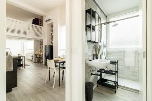 een badkamer met een wastafel en een eetkamer bij Navigli - Chic and Sophisticated Home in Milan in Milaan