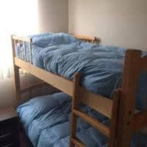 a bedroom with a bunk bed with blue sheets at Marina La Serena, Playa Cuatro Esquinas in La Serena